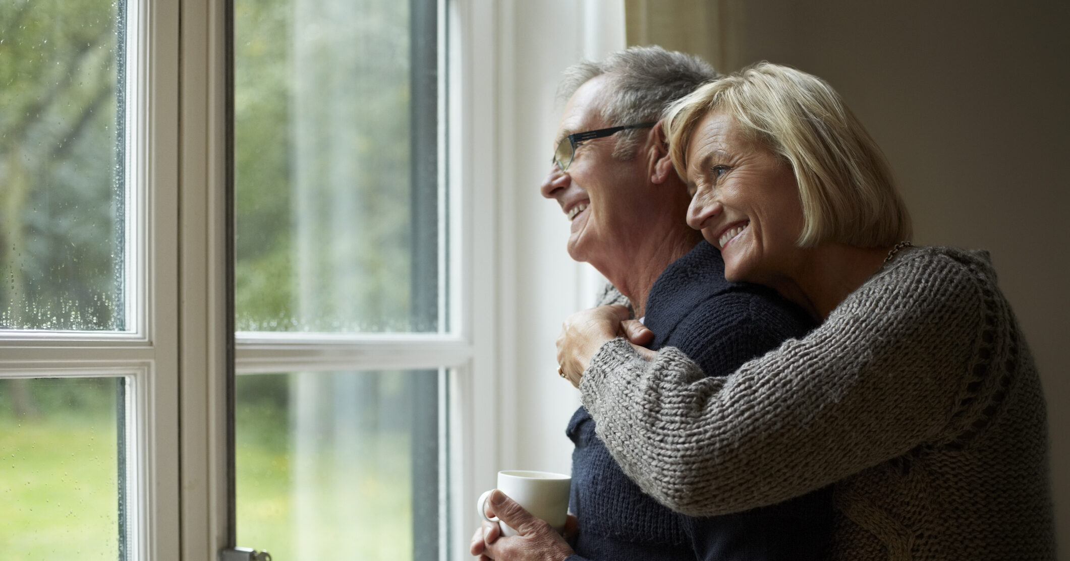 Senior woman embracing man in front of door